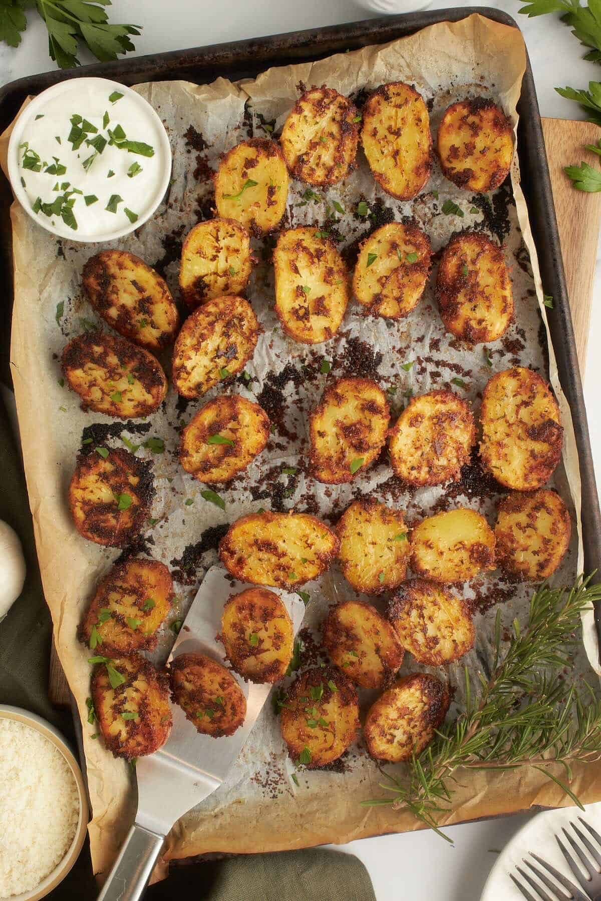 Overhead view of parmesan roasted baby potatoes on a sheet pan, golden brown and crispy from the oven.