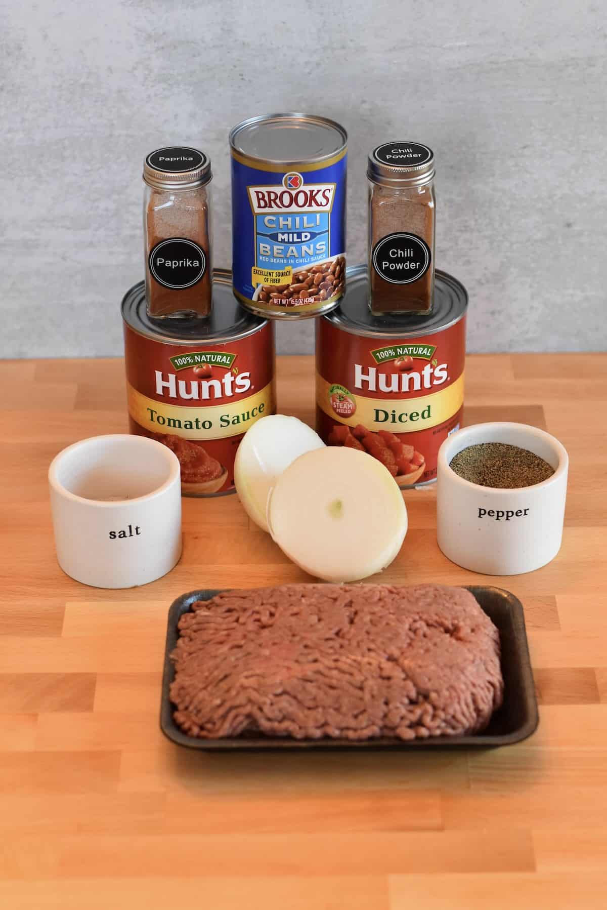 Ingredients for classic chili for a crowd including ground beef, beans, tomatoes, and spices.