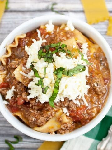 A bowl of hearty lasagna soup topped with three cheeses, fresh from the Instant Pot.