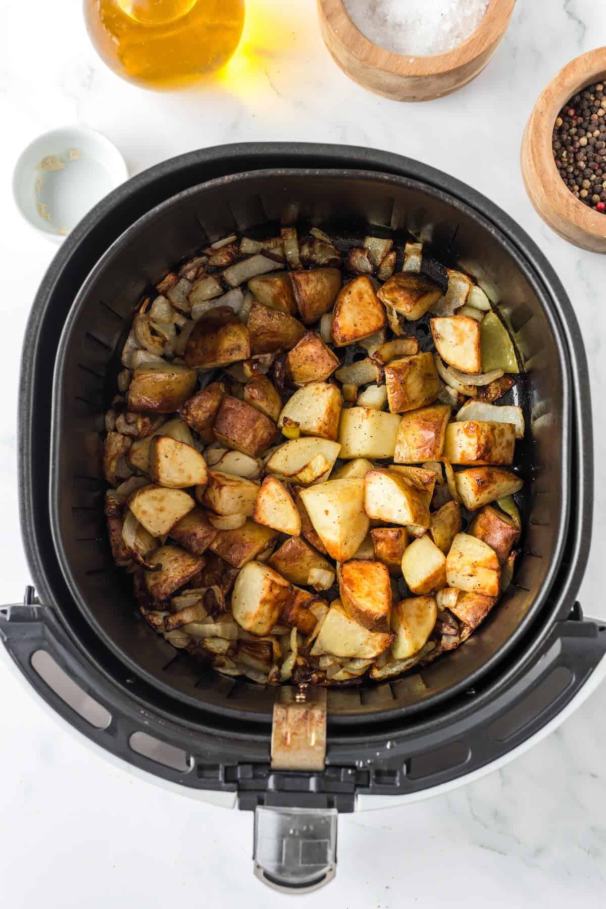 Crispy air fryer breakfast potatoes and onions finished cooking in air fryer.