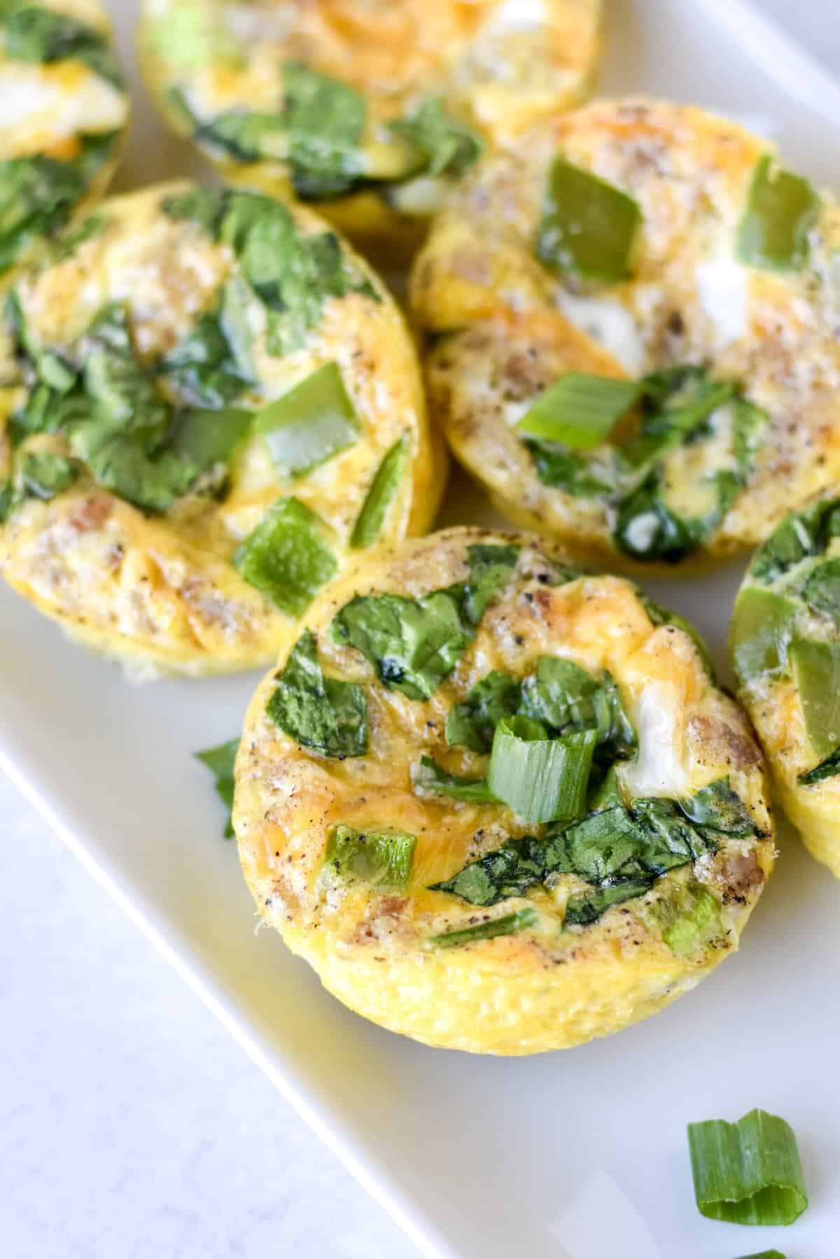 Healthy egg muffins with sausage, spinach and cheddar cheese.