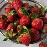 A bunch of strawberries ready to be rinsed, hulled and frozen.