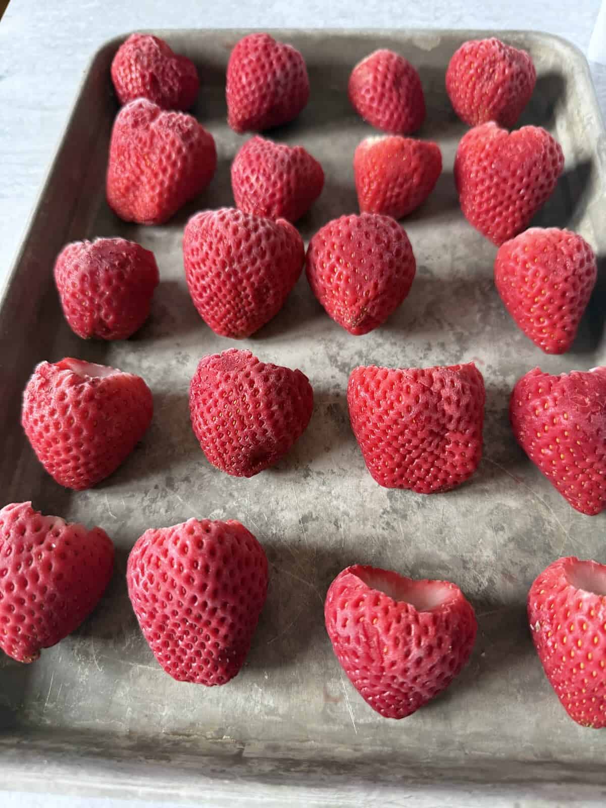 Whole frozen strawberries on a rimmed pan to use in future recipes.