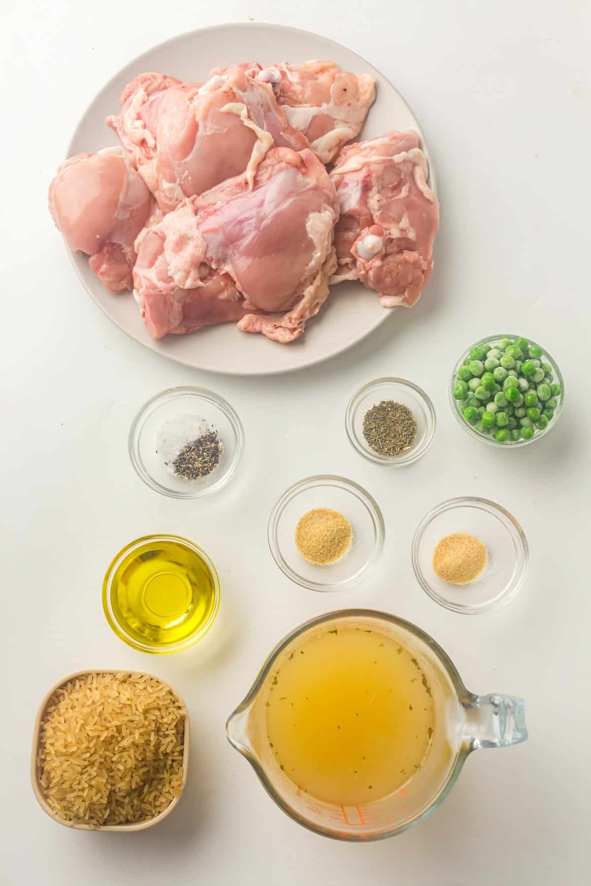 Ingredients for Instant Pot chicken and rice including chicken thighs, rice, broth, and frozen vegetables.
