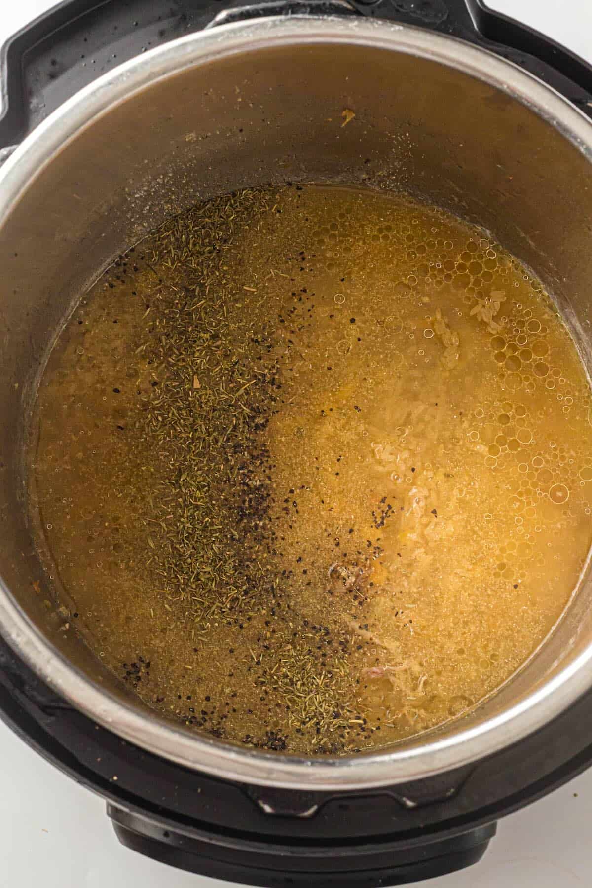 Adding rice and broth to the Instant Pot for chicken and rice.