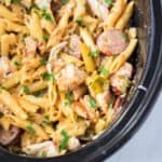 Creamy slow cooker Cajun chicken pasta with sausage, peppers and parmesan cheese.