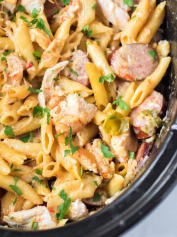 Creamy slow cooker Cajun chicken pasta with sausage, peppers and parmesan cheese.
