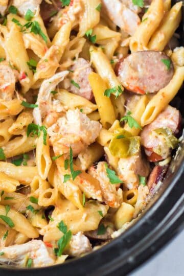 Creamy slow cooker Cajun chicken pasta with sausage, peppers and parmesan cheese.