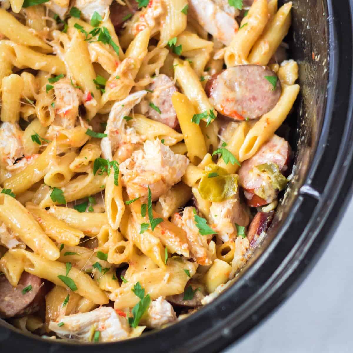 Creamy slow cooker Cajun chicken pasta with sausage, peppers and parmesan cheese.