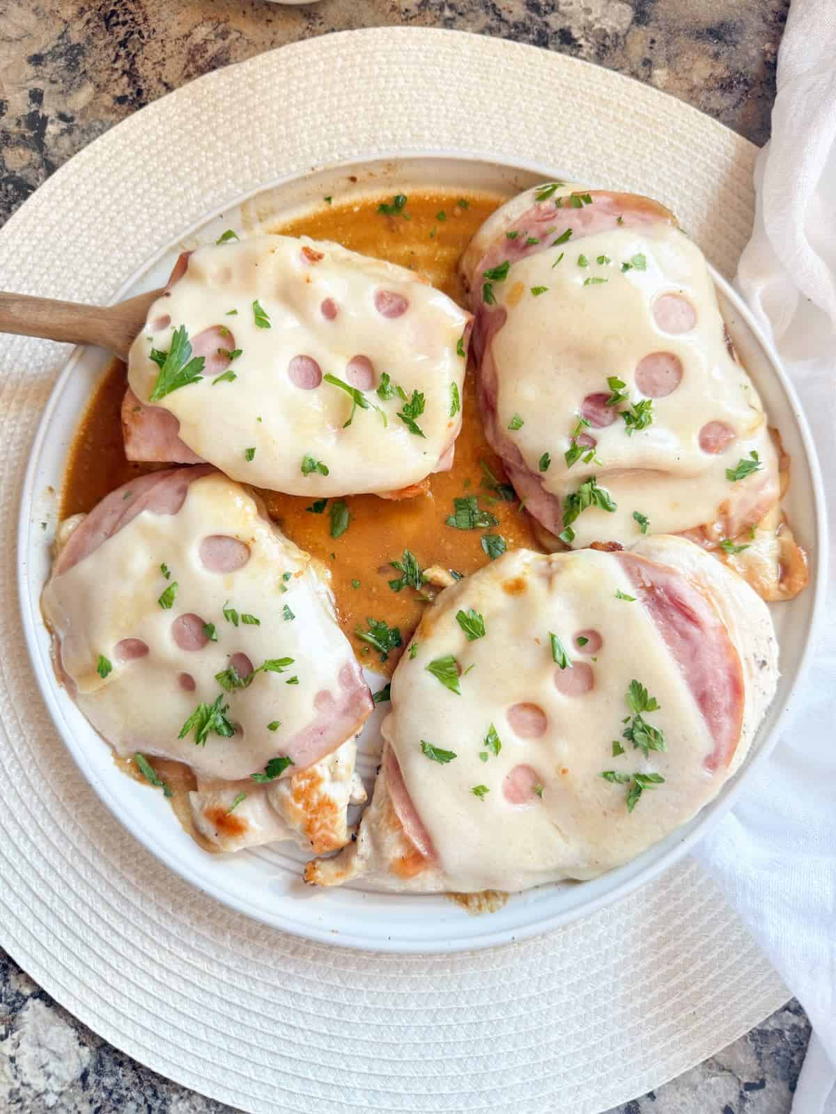 Plated skillet chicken cordon bleu on a plate topped with fresh parsley.