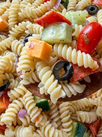 Easy Italian pasta salad made with rotini, vegetables, cheese, and Italian dressing in a large serving bowl.
