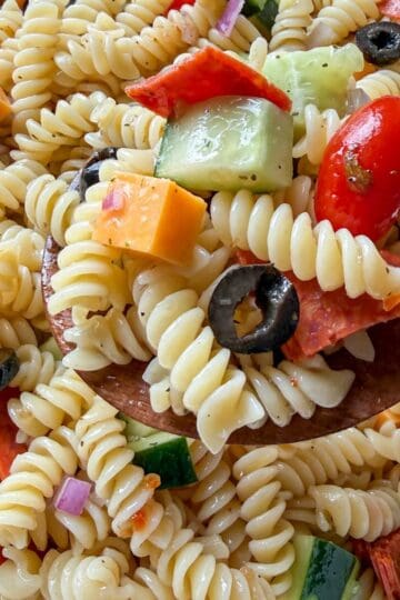 Easy Italian pasta salad made with rotini, vegetables, cheese, and Italian dressing in a large serving bowl.