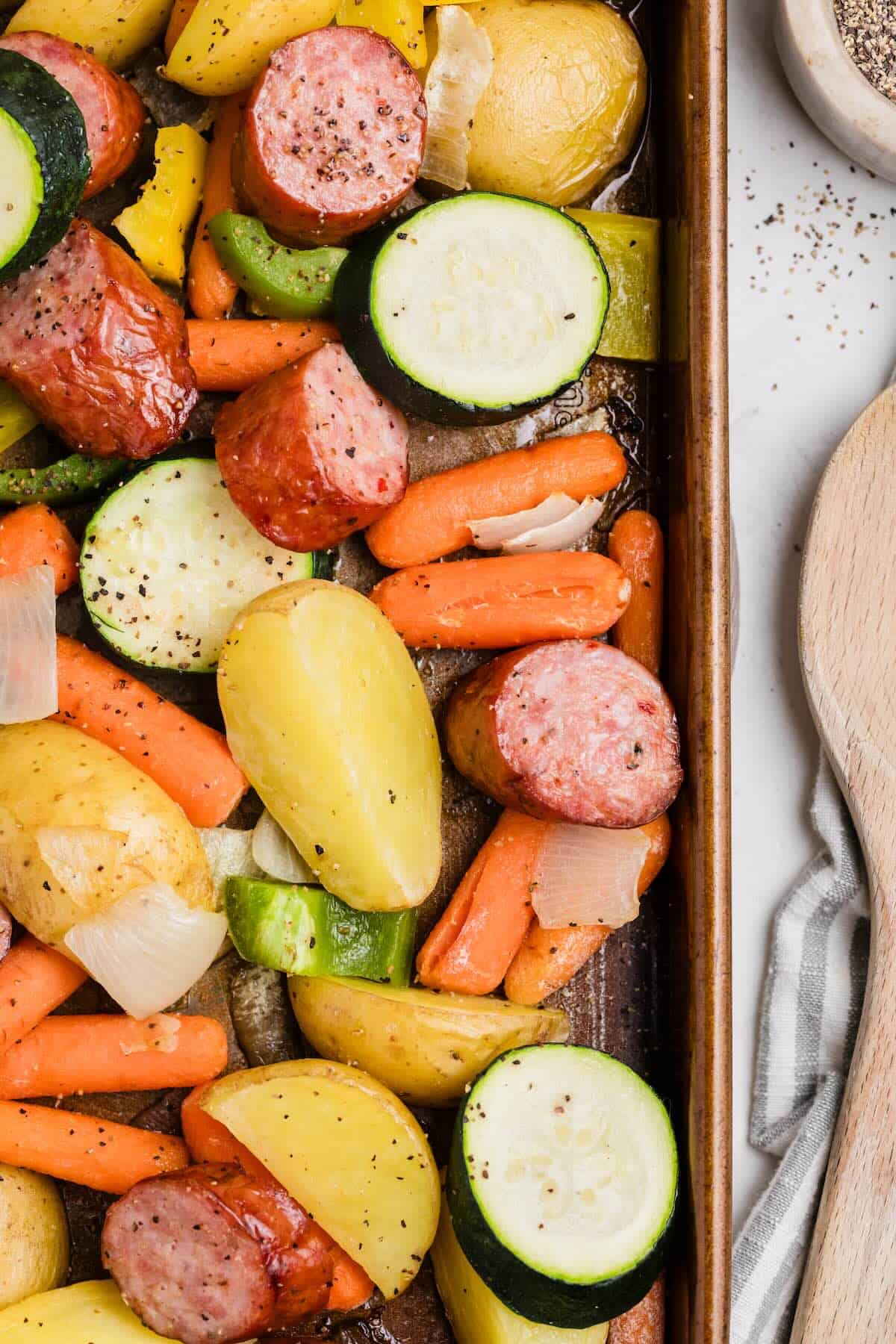 A sheet pan dinner made with smoked kielbasa sausage and vegetables, ready to serve for a one pan dinner.