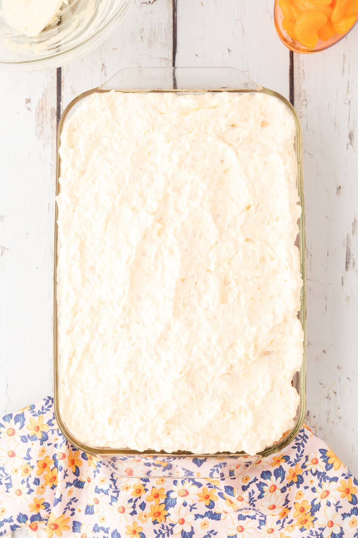 A sunshine cake topped with cool whip and pineapple topping.