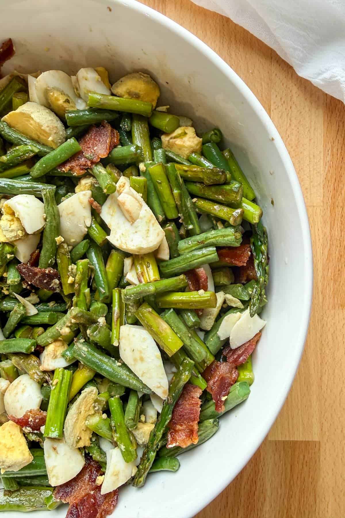 Chilled roasted asparagus and green beans served as a salad with bacon and eggs.