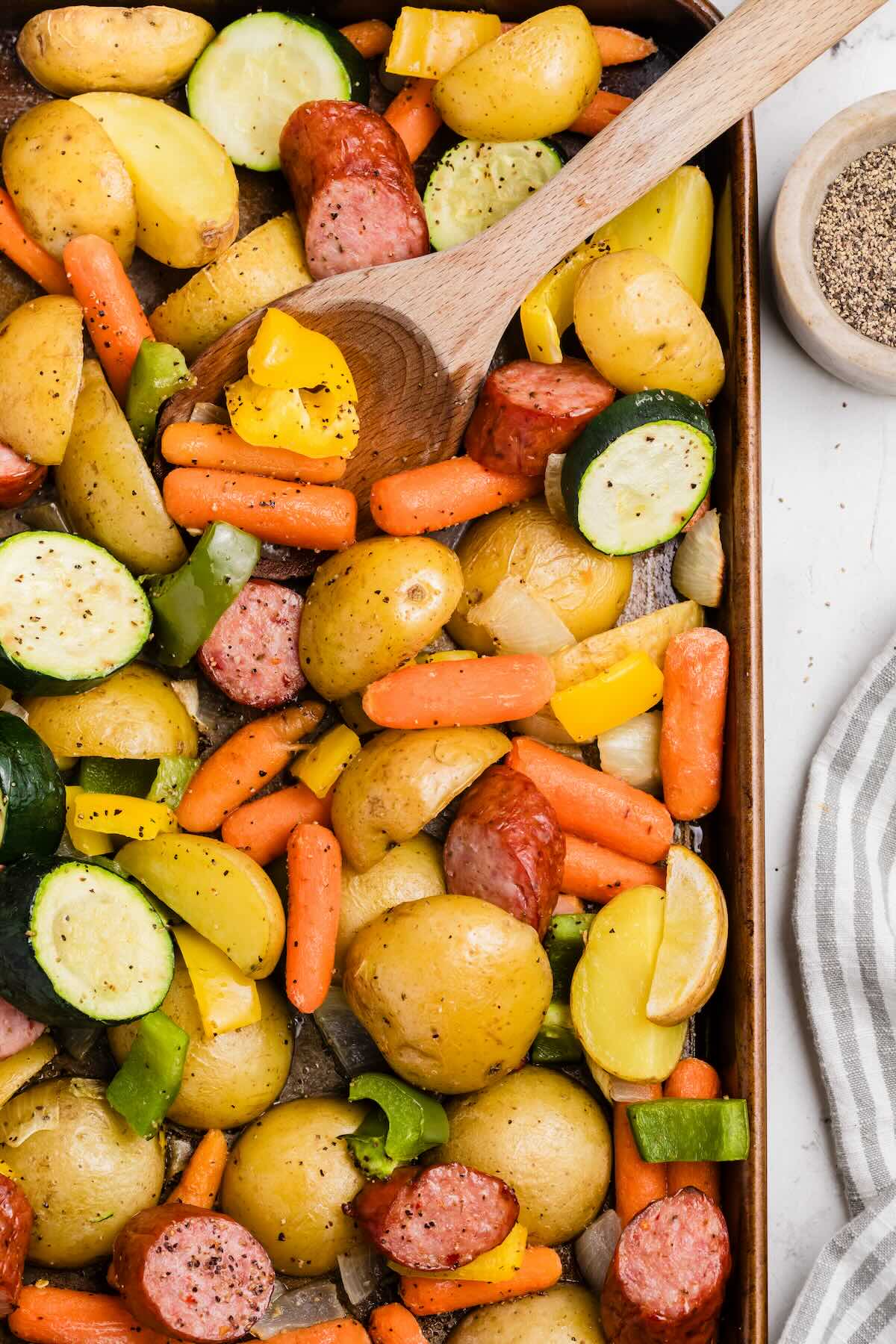 A sheet pan dinner made with smoked kielbasa sausage and vegetables, ready to serve for a one pan dinner.