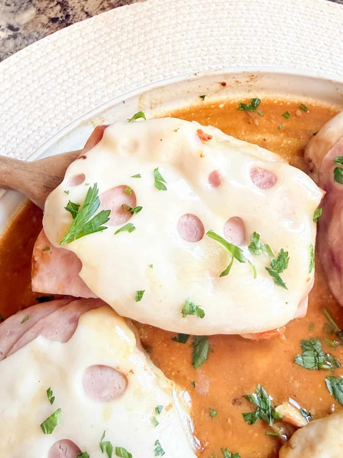 Warm ham and melted Swiss topping a cooked chicken breast.