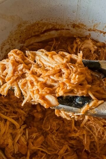 A close up of shredded chicken with bbq sauce made in the crockpot.