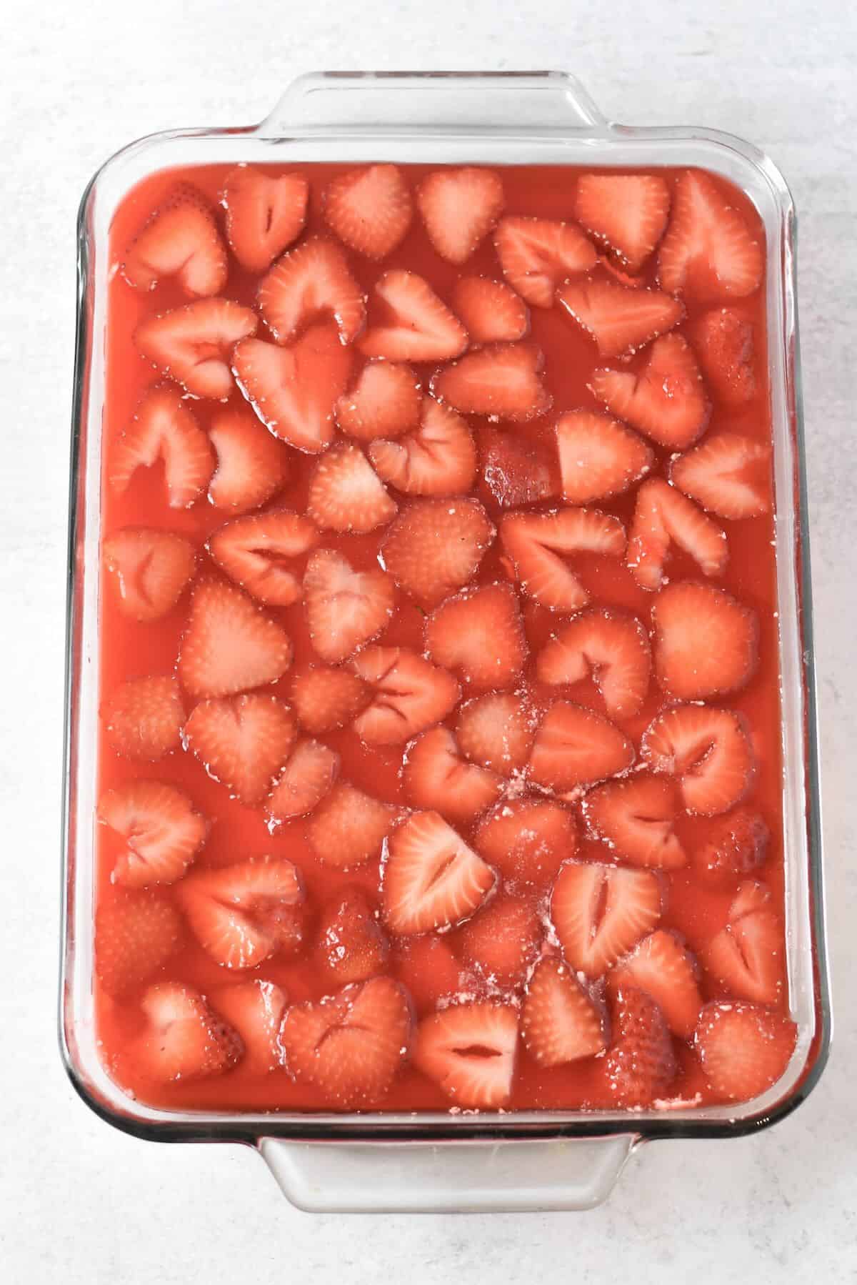 Strawberry pretzel salad assembled in layers before chilling in refrigerator.
