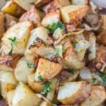 Crispy browned potatoes and onions fresh from the air fryer and garnished with chopped parsley.