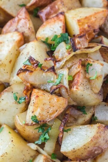 Crispy browned potatoes and onions fresh from the air fryer and garnished with chopped parsley.