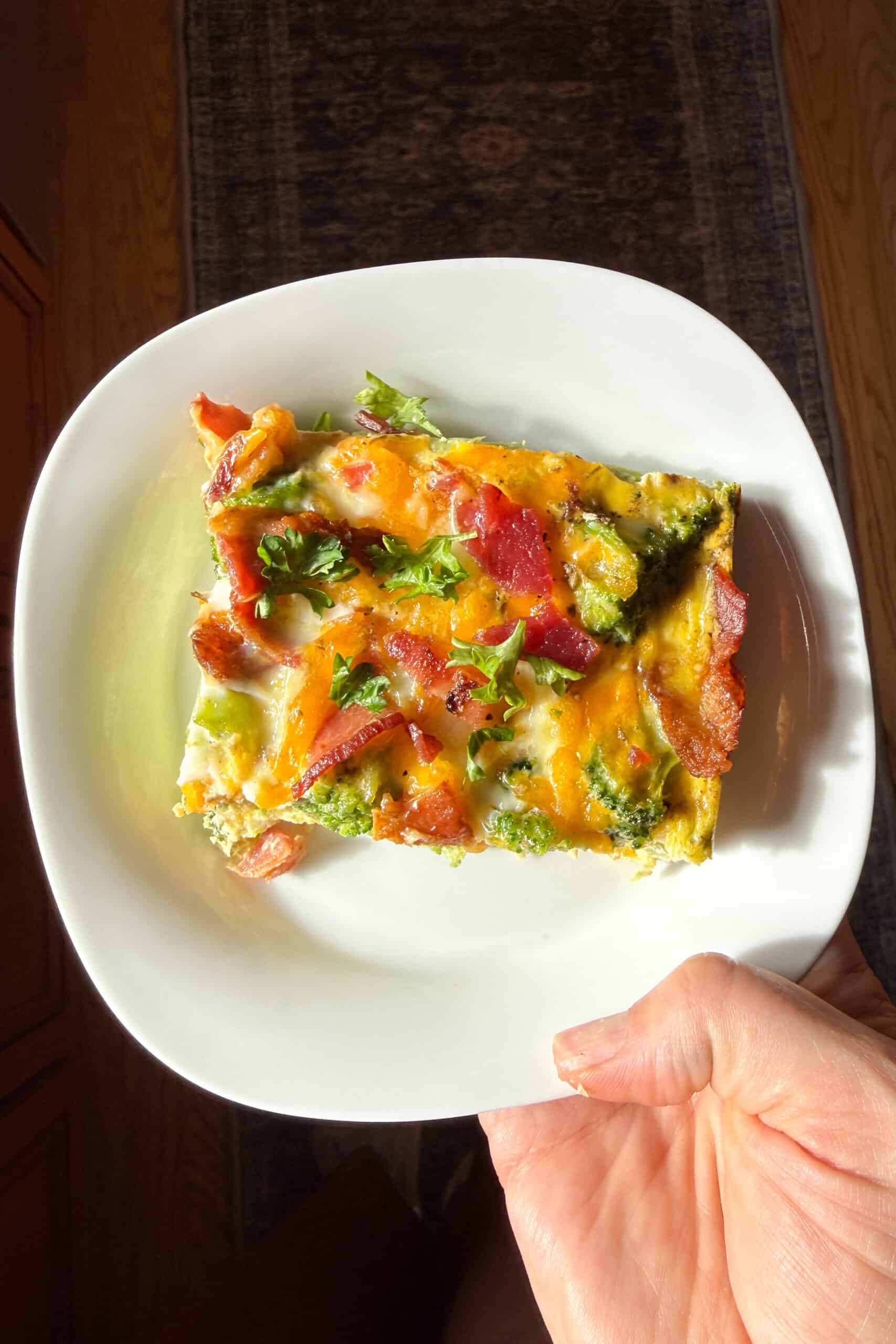 A slice of bacon broccoli breakfast casserole on a plate.