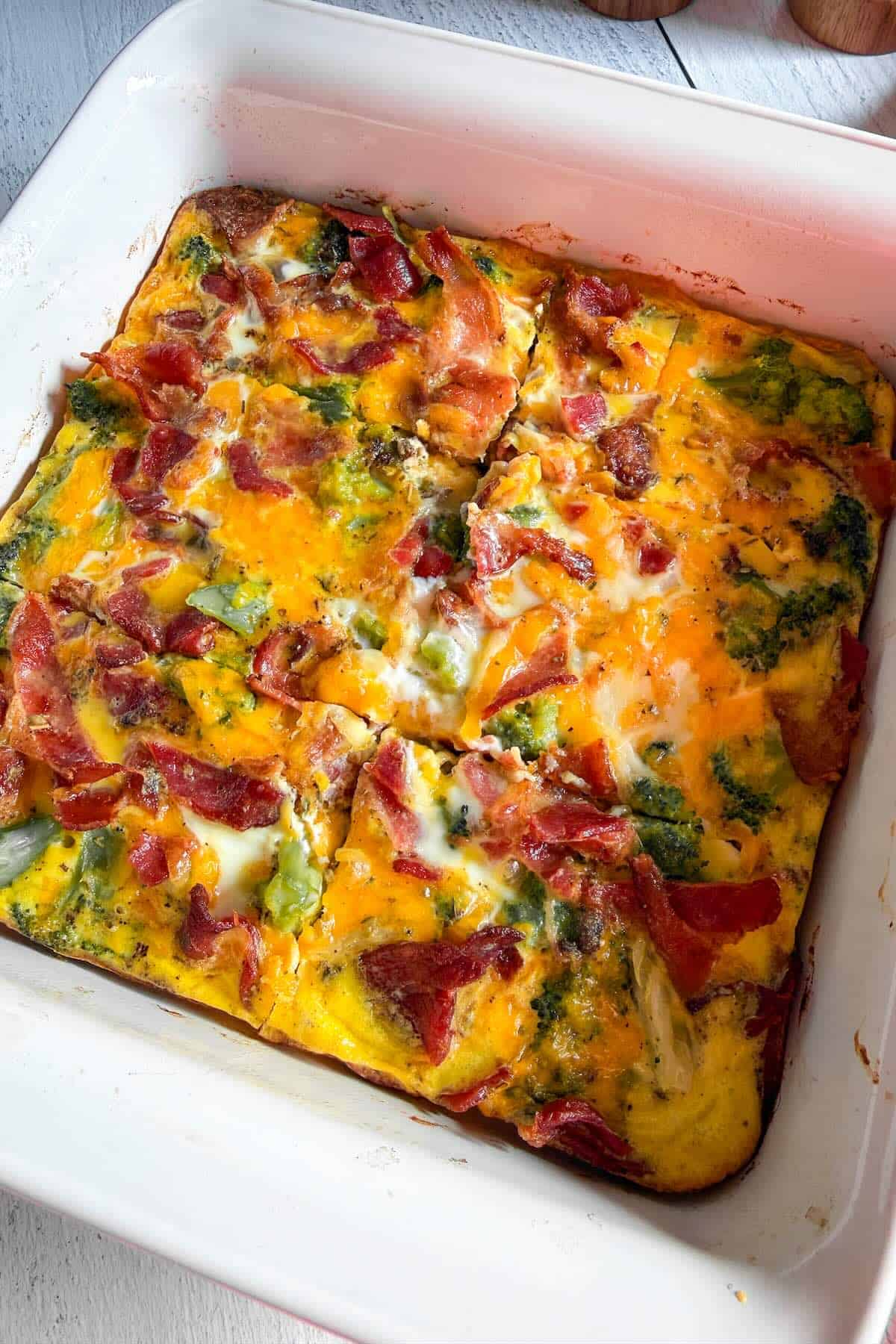 Freshly baked low carb breakfast casserole with bacon, broccoli, and melted cheddar cheese.