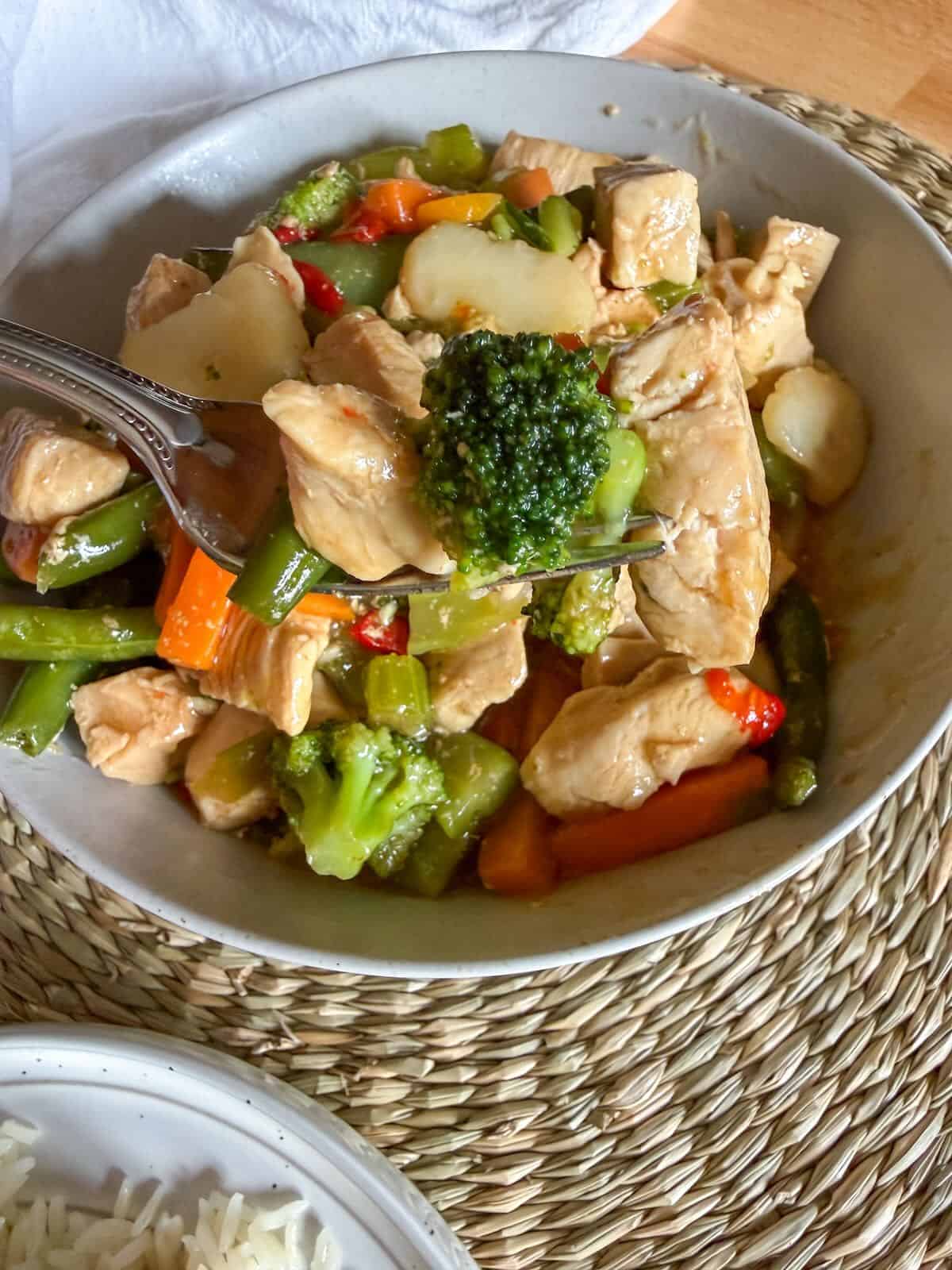 Close up of chicken stir fry with sauce coating and vegetables.