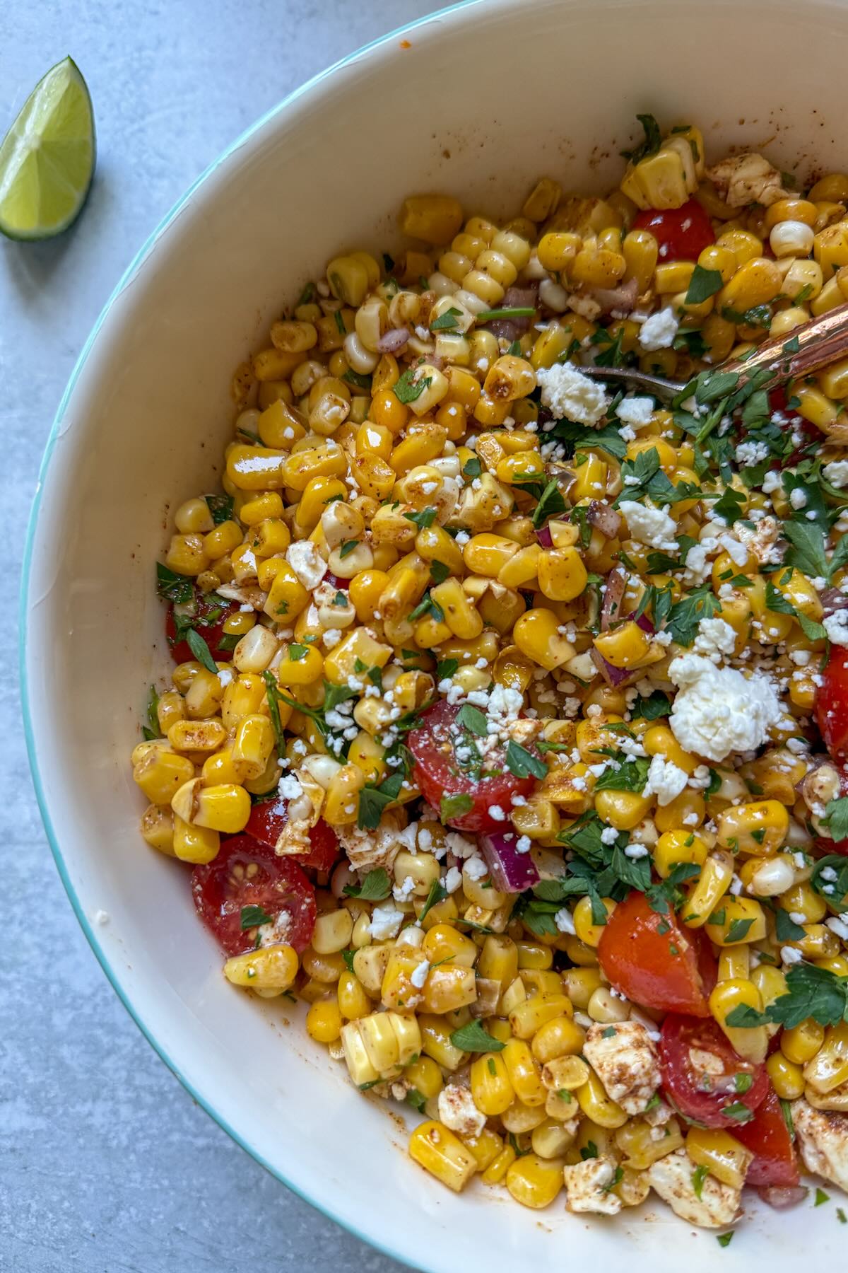 A sweet corn salad dressed with a chili lime dressing, tomatoes and feta cheese.