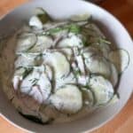 Creamy cucumber salad with sour cream and fresh dill in a serving bowl.