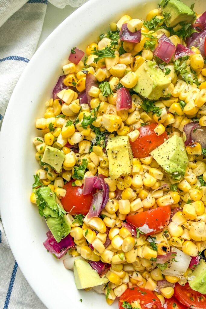 Overhead view of grilled corn salad with avocado and tomatoes.