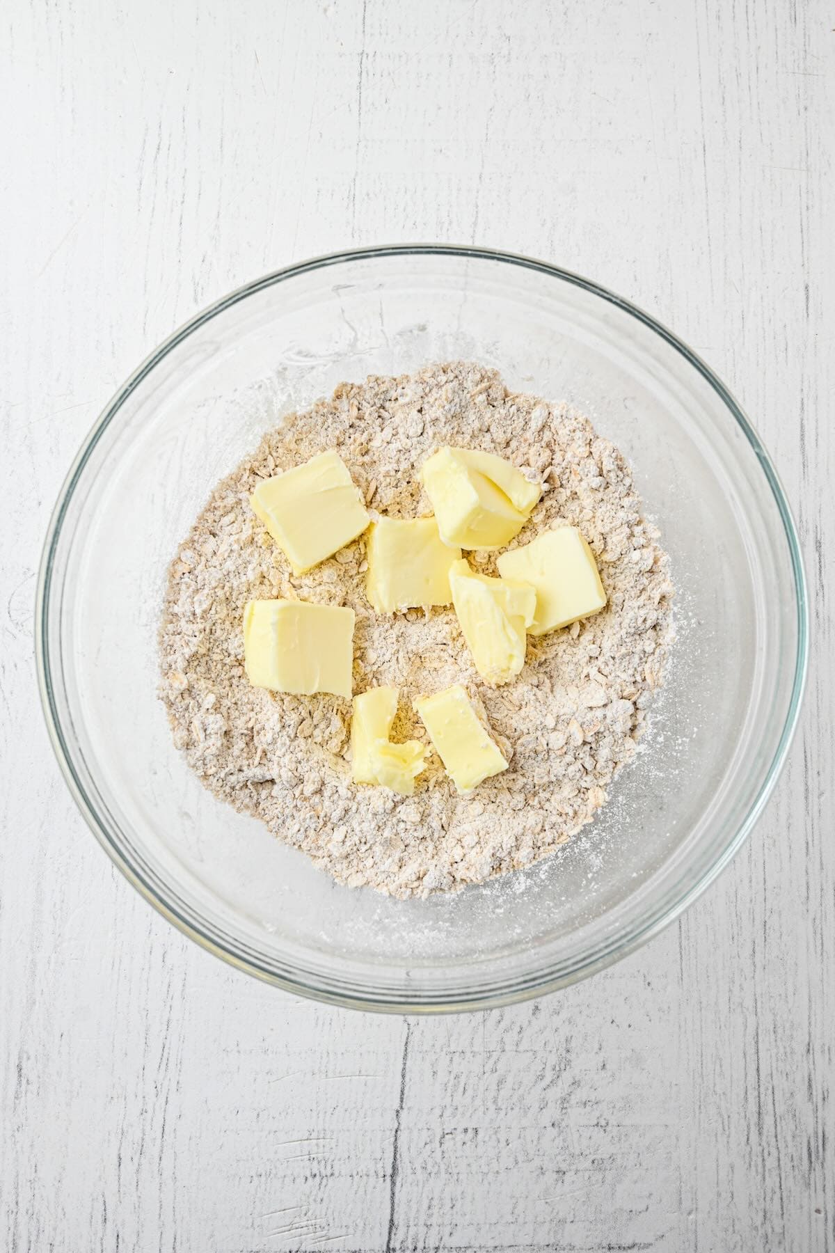 Butter to be mixed into oat mixture creating a crumbly texture for raspberry oatmeal bars.