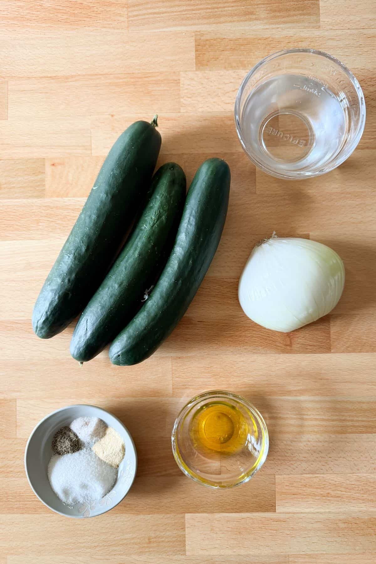 Cucumbers, onions, vinegar and spices for making a vinegar cucumber salad.