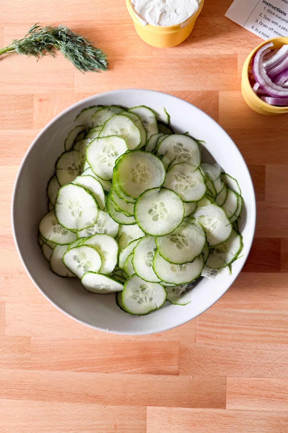 Thinly sliced cucumbers for creamy cucumber salad.