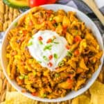 Overhead view of cheesy crockpot taco pasta made with ground beef, black beans, corn, and pasta.