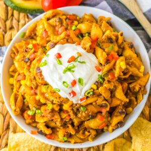 Overhead view of cheesy crockpot taco pasta made with ground beef, black beans, corn, and pasta.