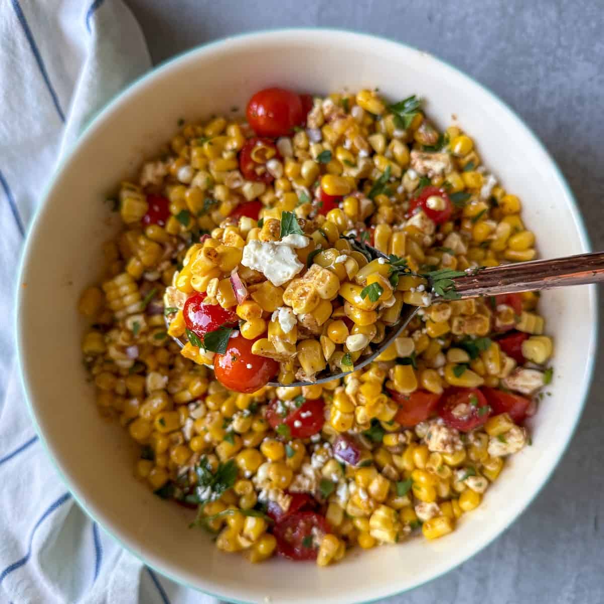 A summer salad made with sweet corn, tomatoes, feta cheese and a simple homemade dressing.