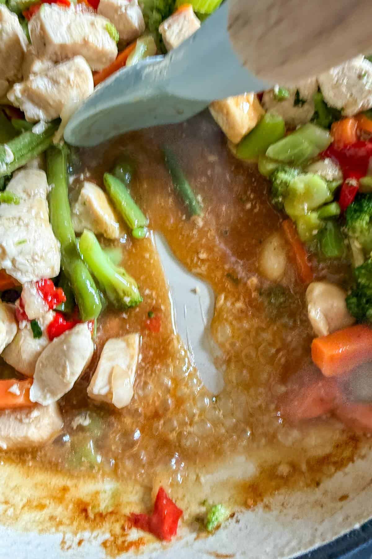 Thickened sauce coating the stir fry chicken and vegetables.