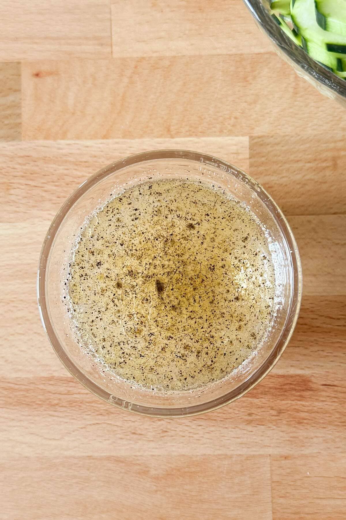 Whisked vinegar marinade for cucumbers and onions.