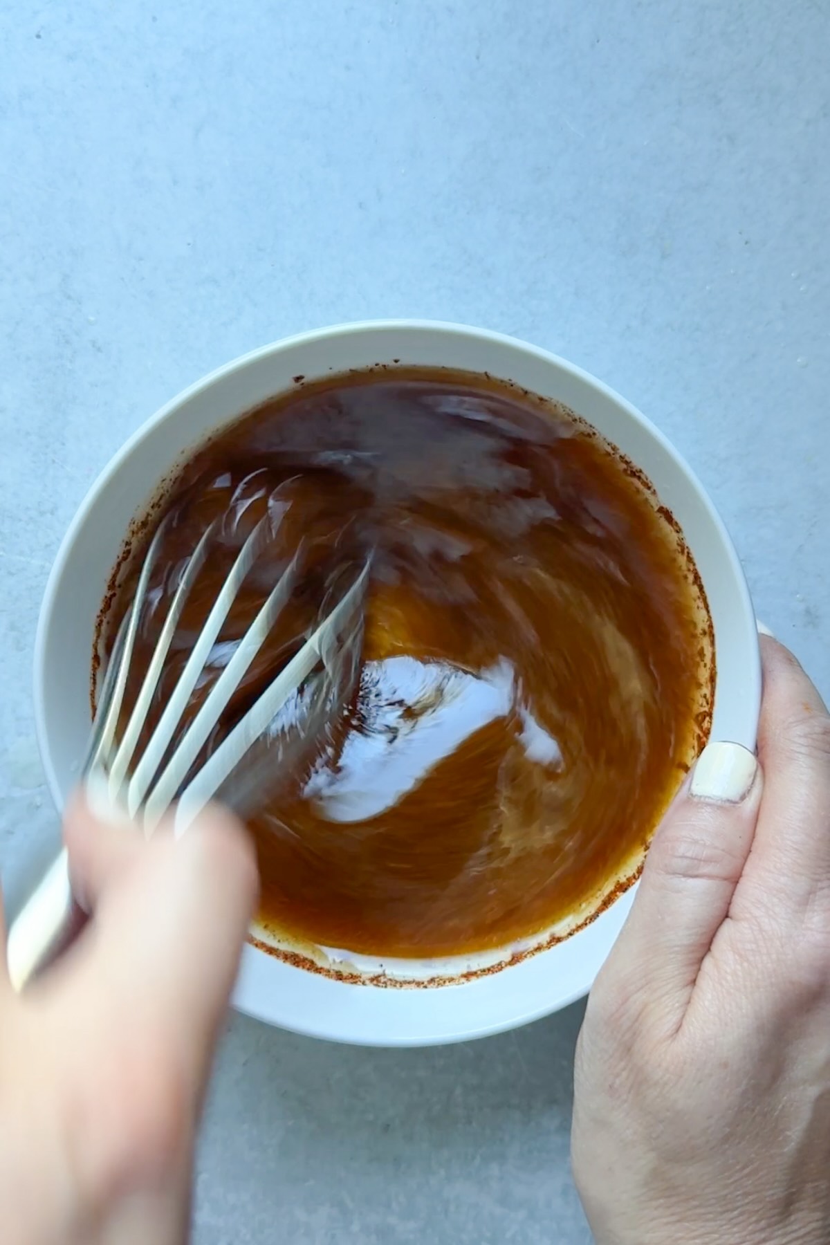 Whisking a chili lime dressing in a bowl.