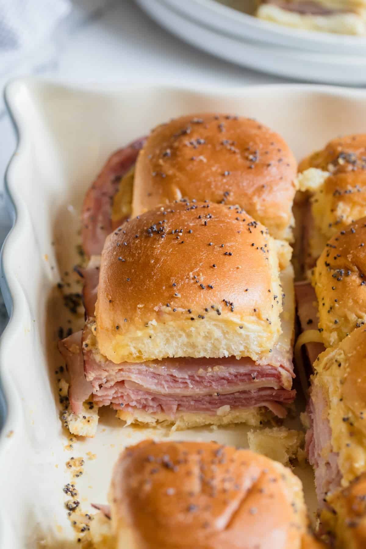Baked ham and cheese sliders in a casserole dish.