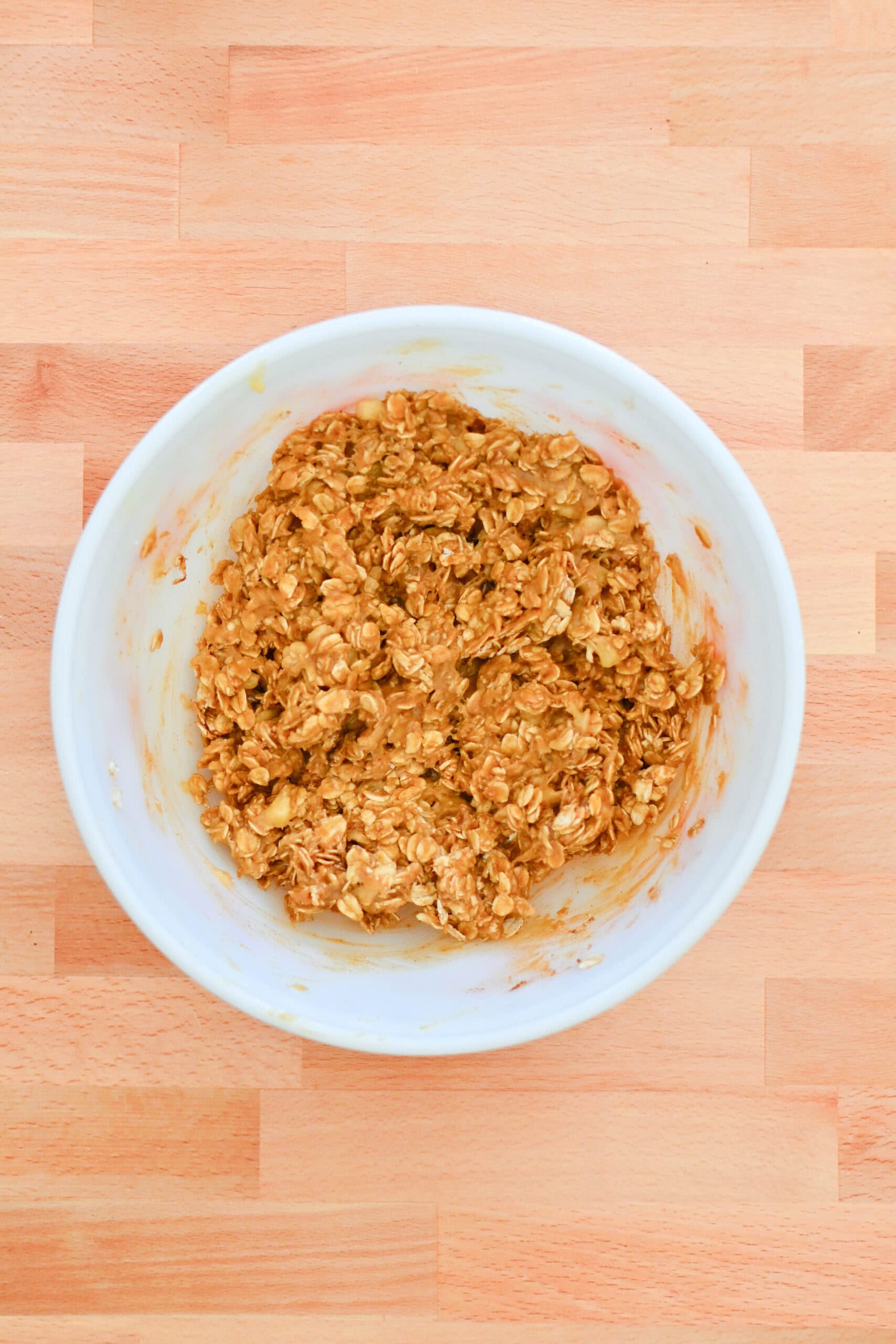 Banana oatmeal breakfast cookie dough mixed together in a bowl before baking.