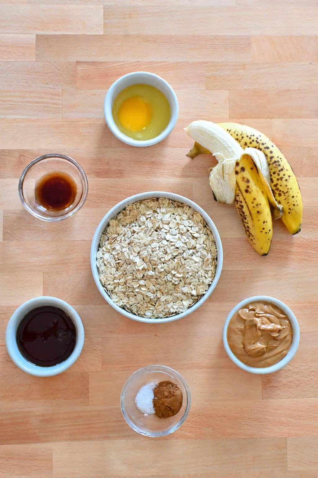 Ingredients for banana oatmeal breakfast cookies including oats, banana, peanut butter, honey, and cinnamon.