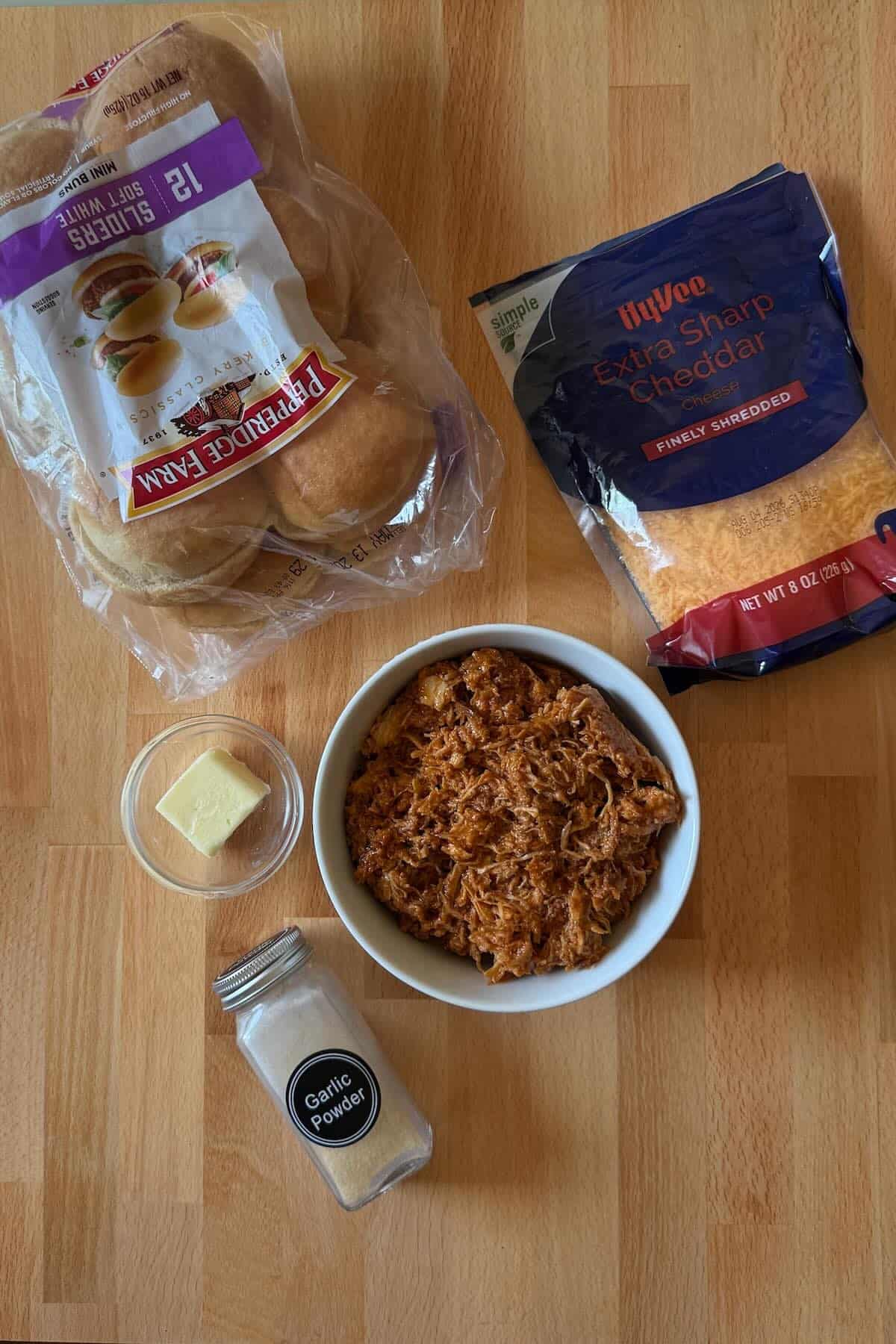 Shredded chicken with bbq sauce, seasonings, buns and cheddar cheese.