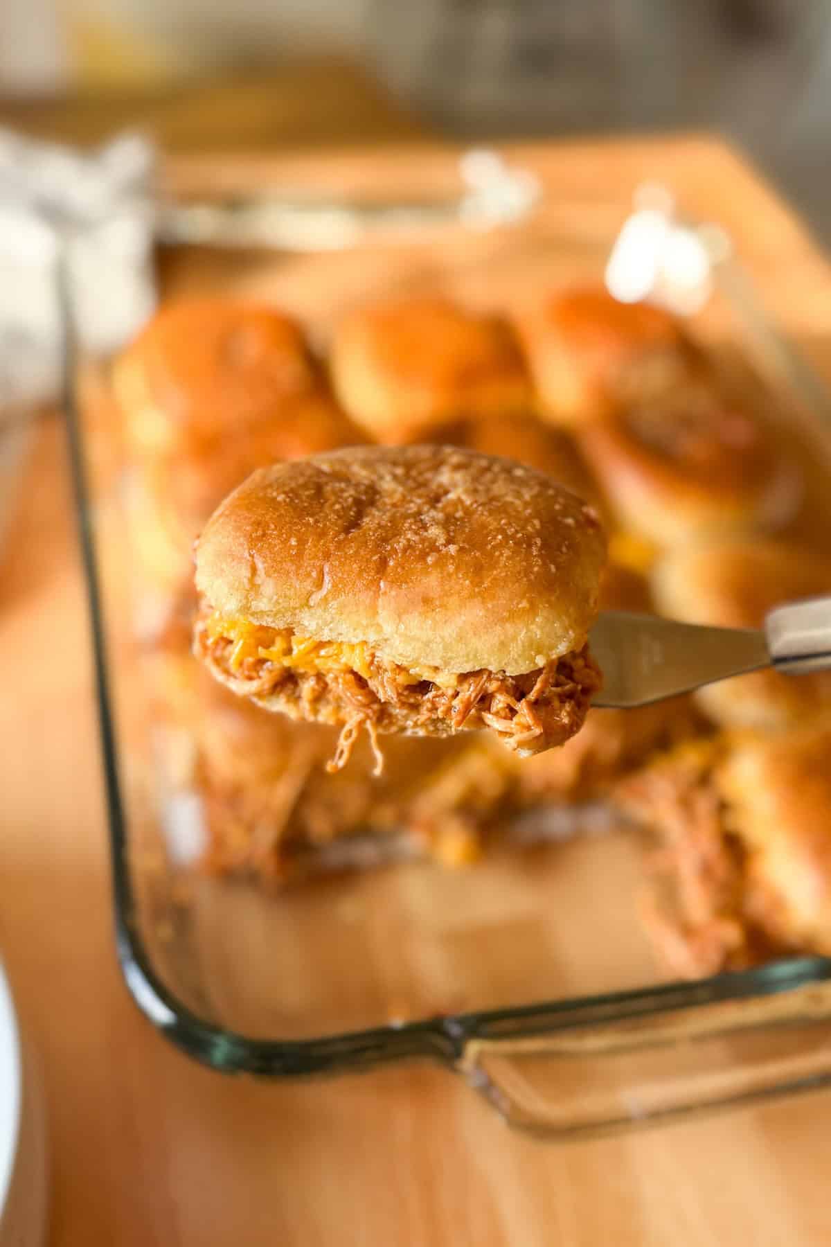 BBQ chicken sliders made with shredded chicken, melted cheese, and Hawaiian rolls baked until golden brown.