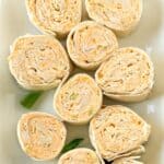 Buffalo chicken pinwheels on a platter as an appetizer.