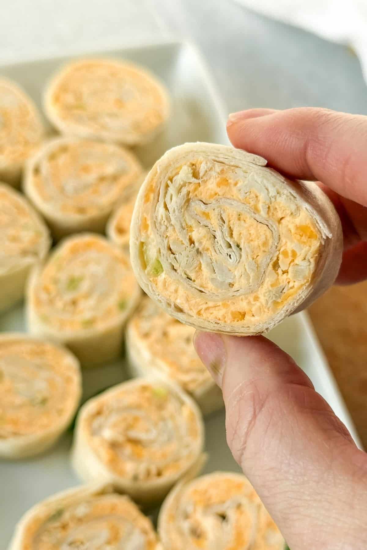Close-up of buffalo chicken ranch pinwheels made with shredded chicken, cream cheese, and buffalo sauce.