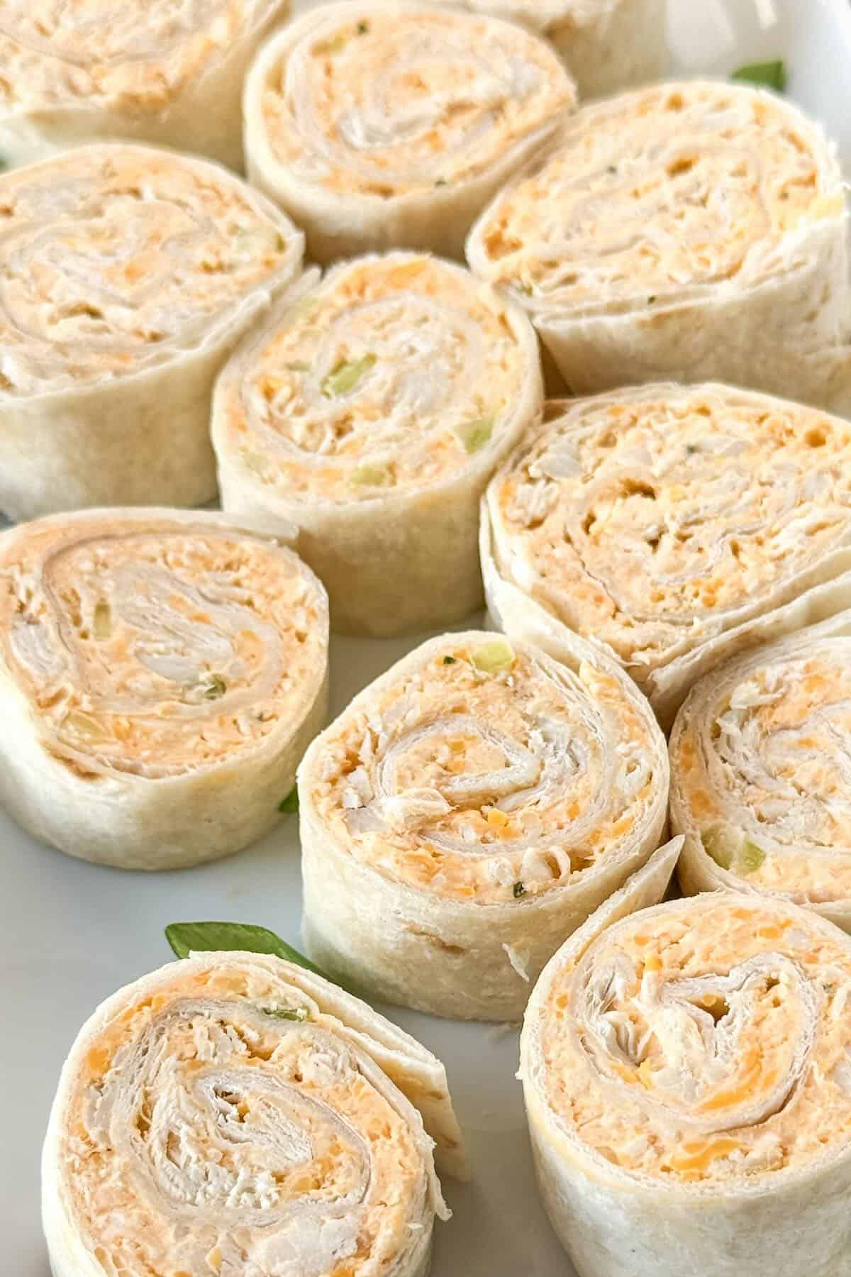 Buffalo chicken ranch pinwheels arranged on a serving platter for a party appetizer.