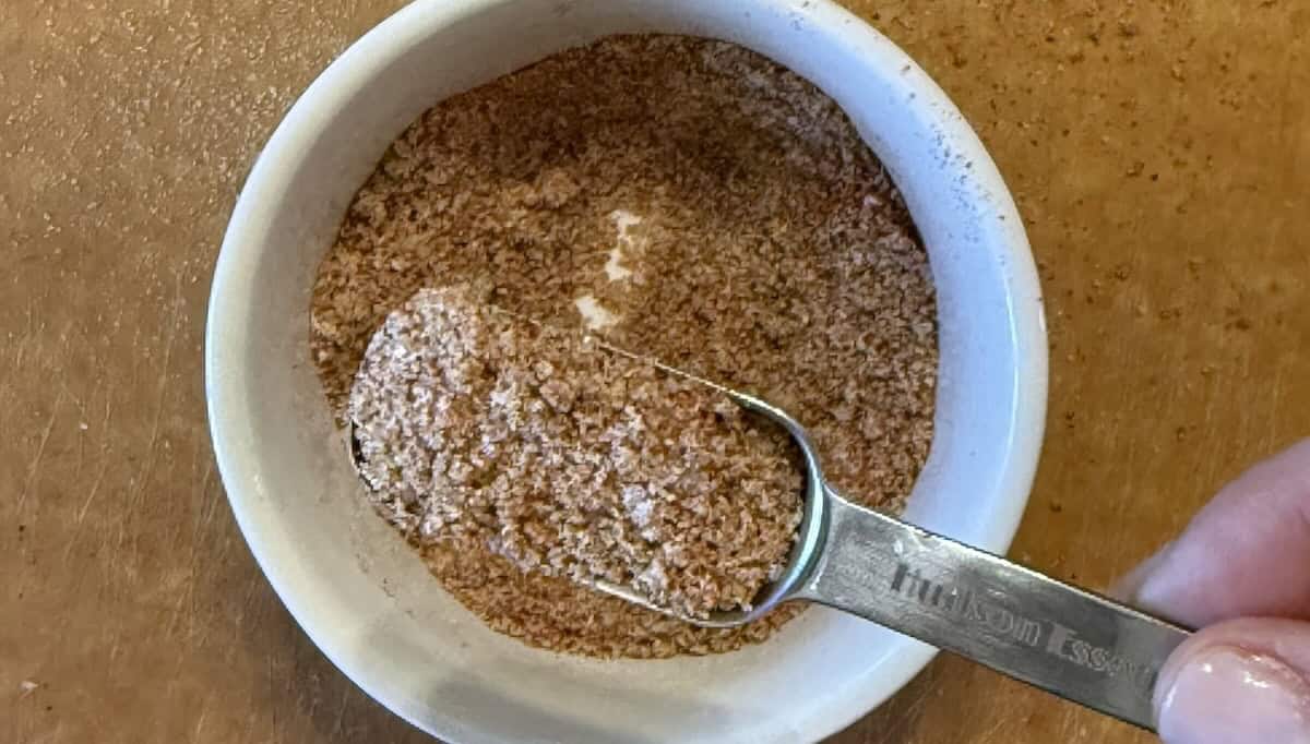 Ingredients for homemade farmhouse BBQ rub including brown sugar, paprika, garlic powder, and chili powder.