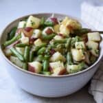 A large bowl of green beans and potato salad, perfect for feeding a crowd.